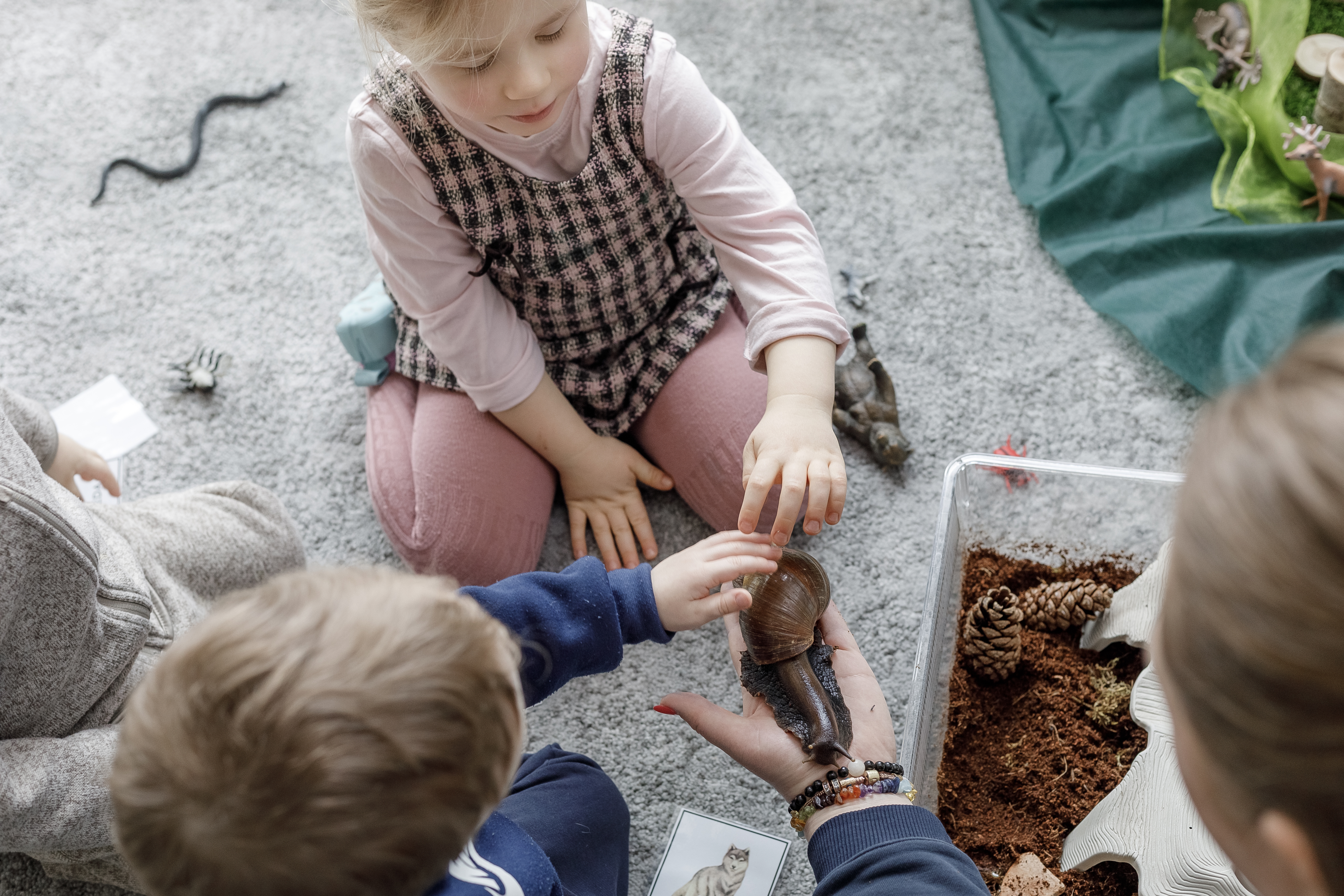 Vaikai tyrinėja jutiminę medžiagą ant grindų
