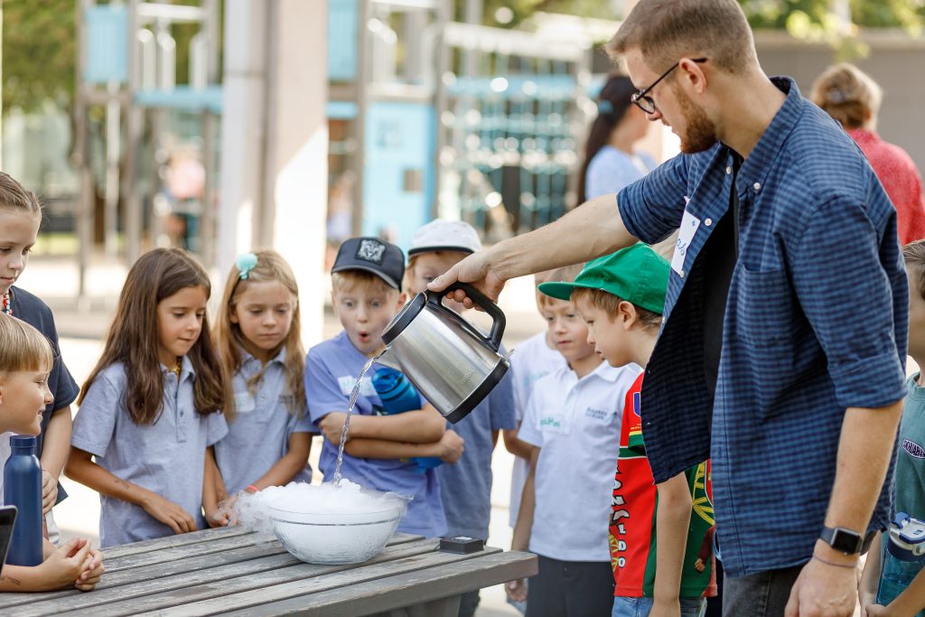 Mokytojas su vaikais atlieka bandymą lauke