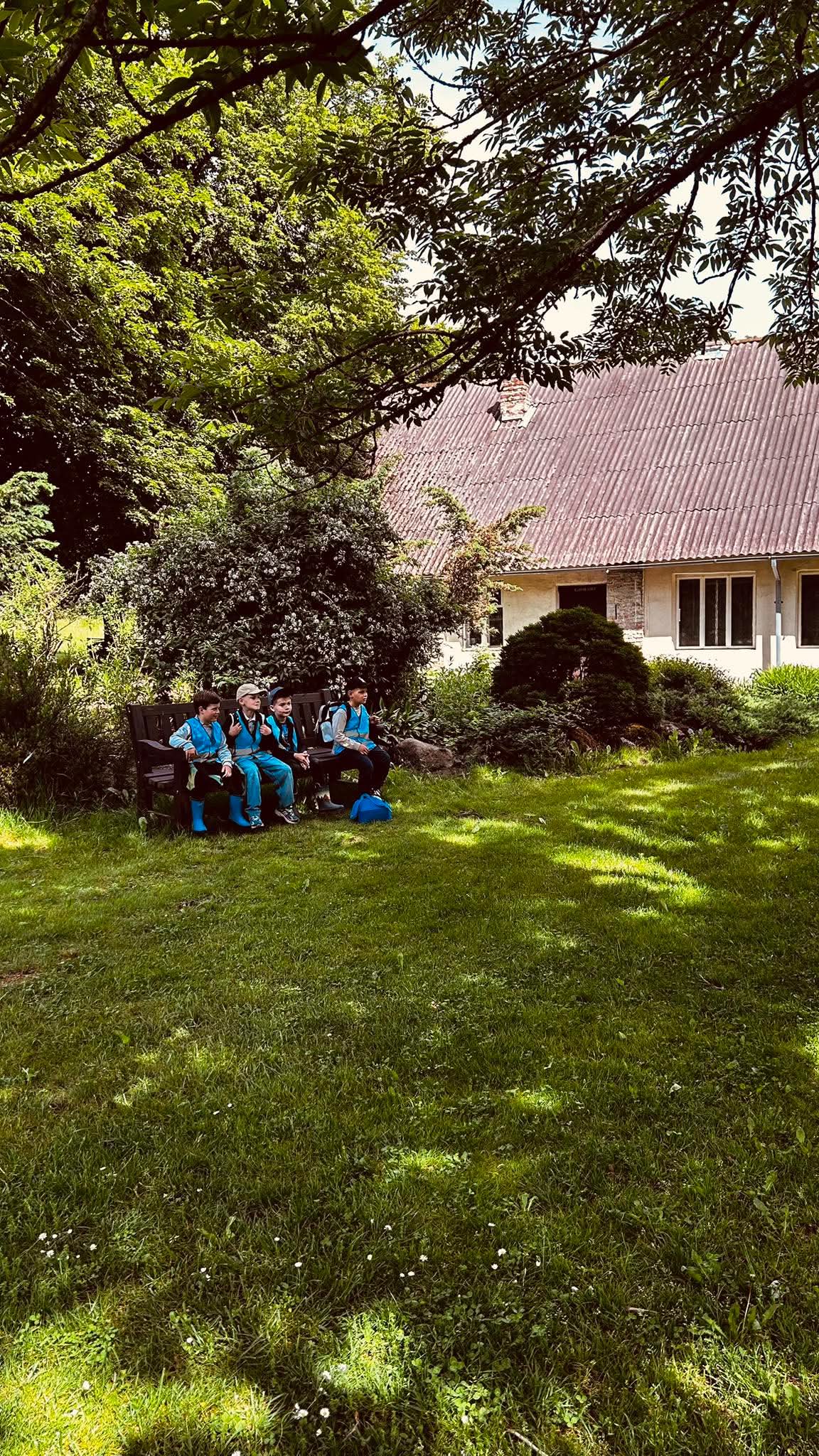 Mokiniai pavėsyje botanikos sode